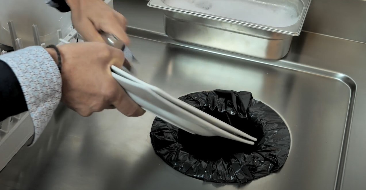 Action de dérusher une assiette avant de l’insérer dans votre lave-vaisselle professionnel